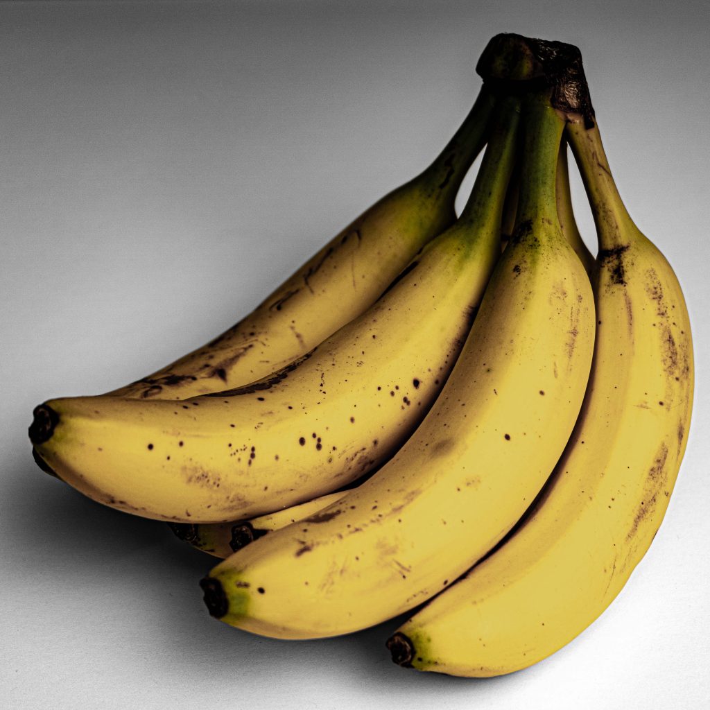 A dark, moody photograph of a bunch of bananas.