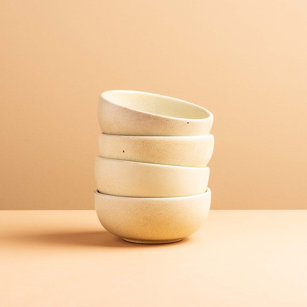 Product photo of four stacked white ceramic bowls.